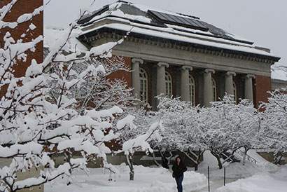 Snow covers trees in front of Old Main building